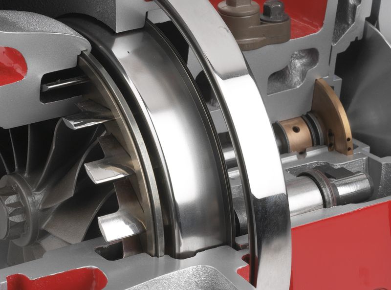 Close-up of a sectioned turbocharger core: compressor wheel, shaft and bearing assembly